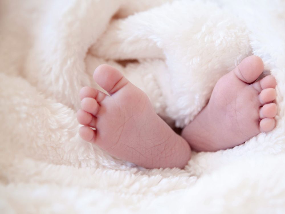 baby's feet wrapped in pink blanket